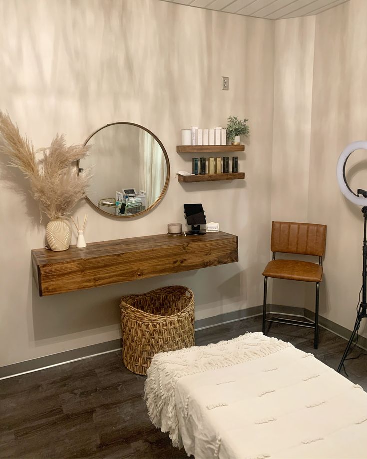 a room with a bed, mirror and two wooden chairs in front of the wall