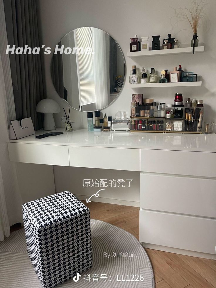 a white vanity with drawers and a mirror on it's wall next to a stool