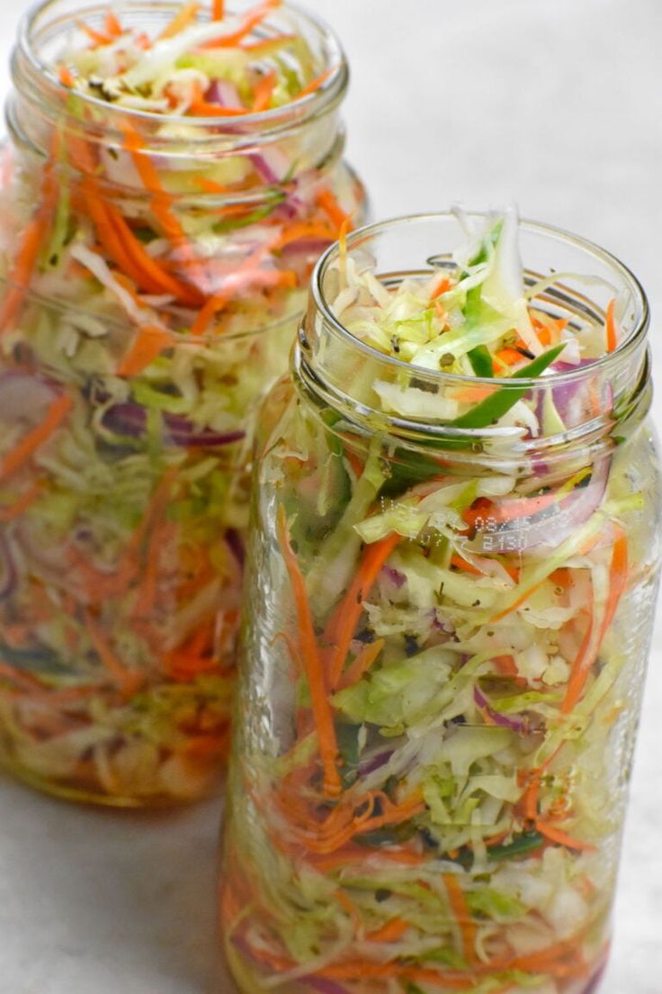 three mason jars filled with different types of salads and veggies in them