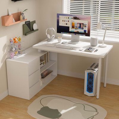 a white desk with a computer on top of it next to a book shelf and window