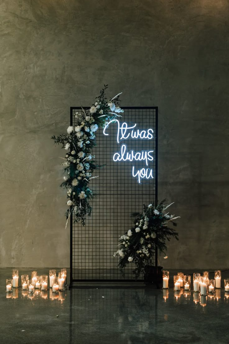 there is a sign that says always always you with flowers and candles in front of it