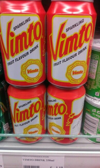 three cans of soda sit on display in a grocery store's cooler shelf, with the label saying vinto