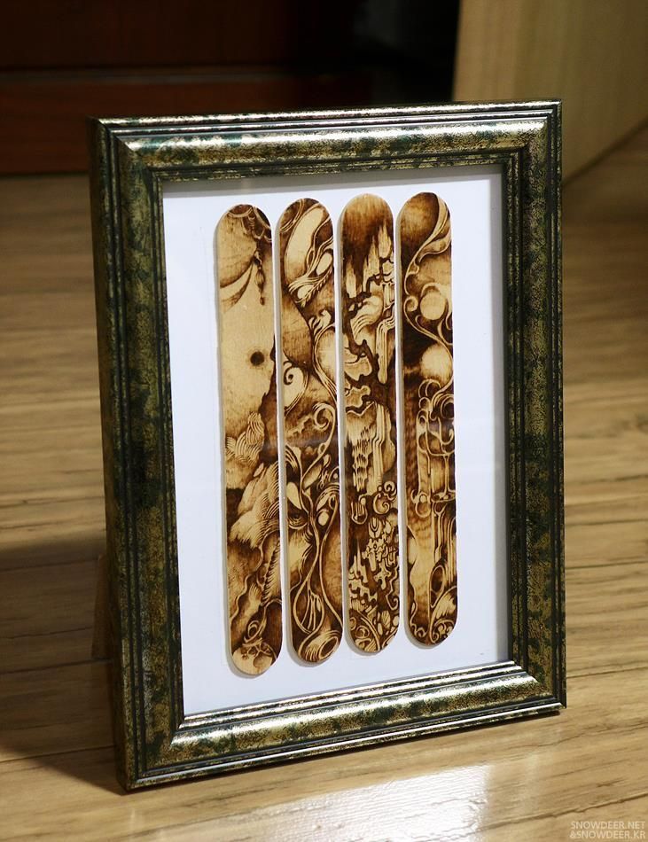 an image of wooden spoons in a frame on a table with wood flooring