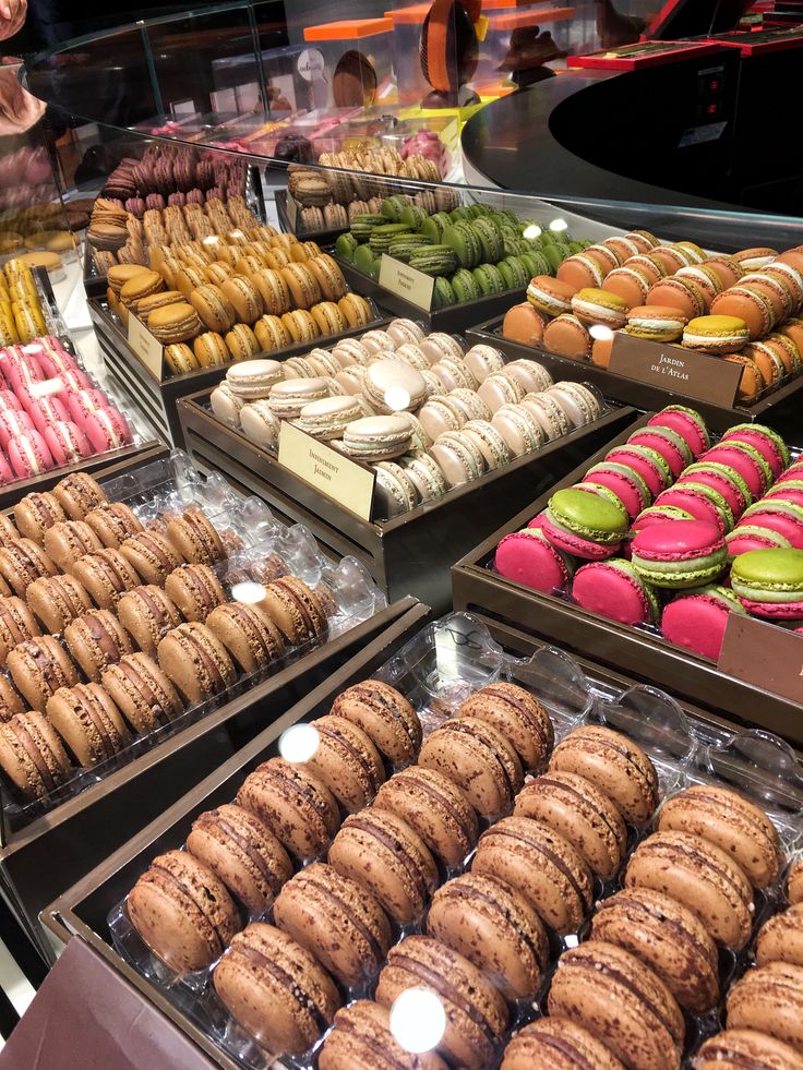 a display case filled with lots of different flavored donuts and macaroons