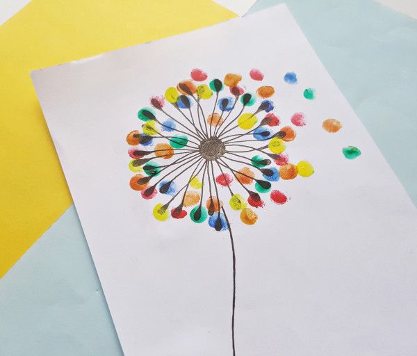 a dandelion made out of colored crayons on top of white paper