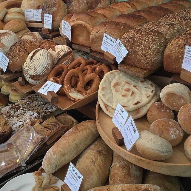 many different types of breads and pastries on display