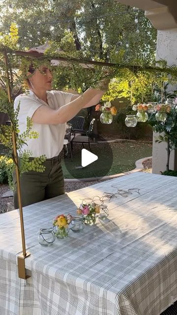 a woman is holding an umbrella over a table