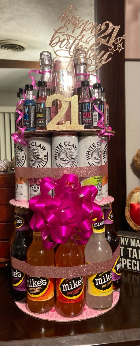 there is a cake made to look like a tower with beer bottles and pink bows