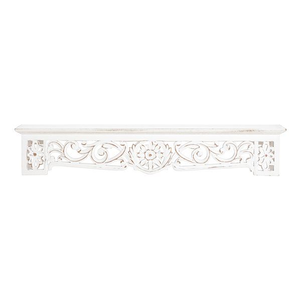 a white shelf with ornate carvings on it's sides and an openwork design at the top