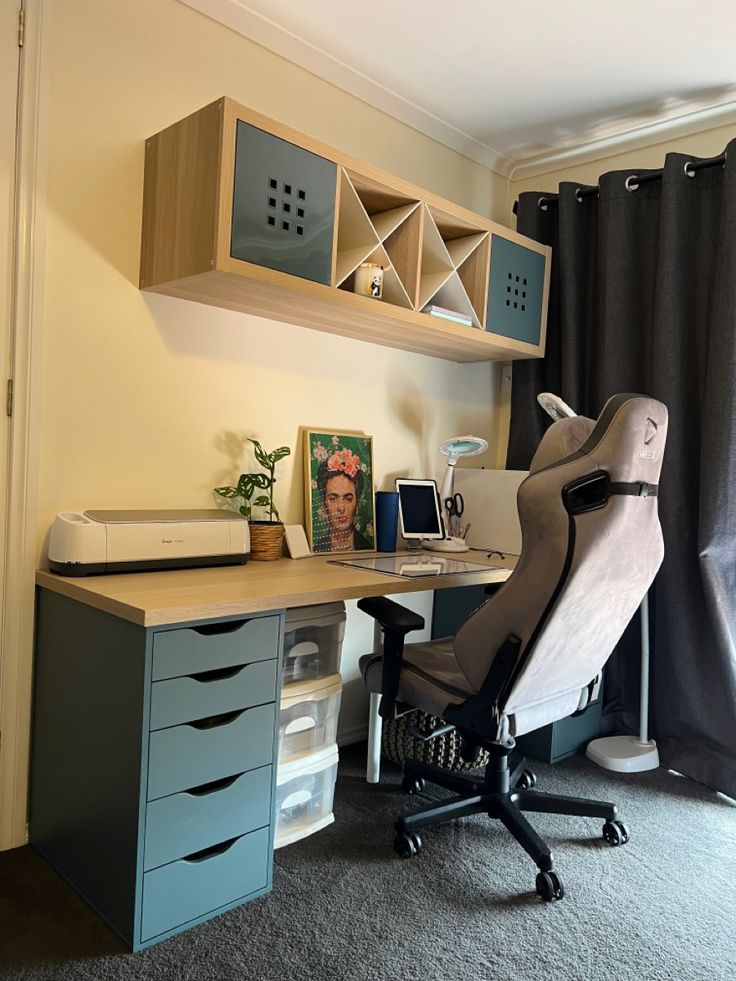 an office chair sits in front of a desk with drawers and shelves on the wall