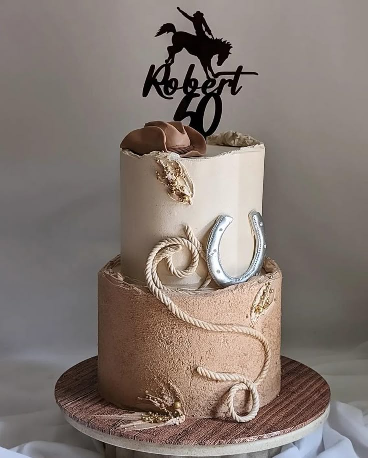 a birthday cake with a horse and rope decoration on the top is decorated in pink, white and gold