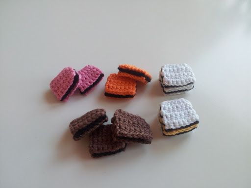 small crocheted pieces of bread sitting on top of a white table next to each other