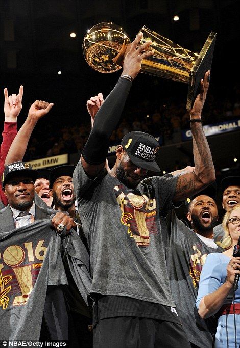 a group of men standing next to each other holding up trophies