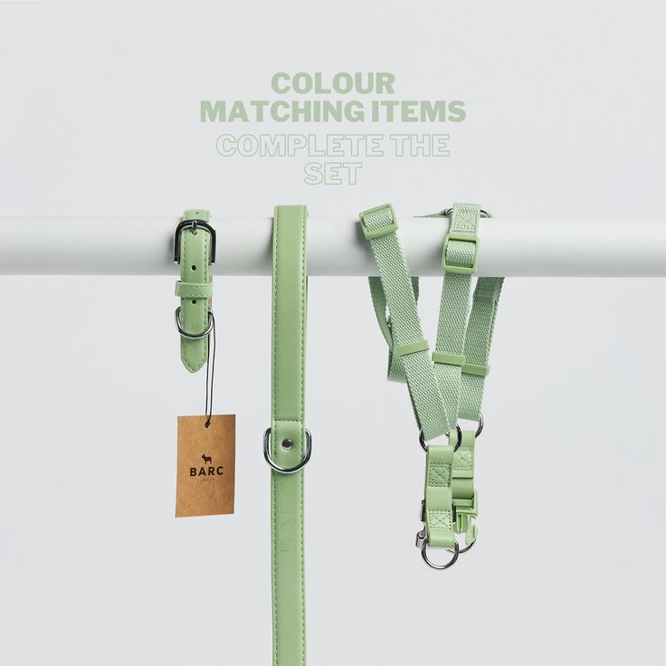 two green straps hanging from a white pole