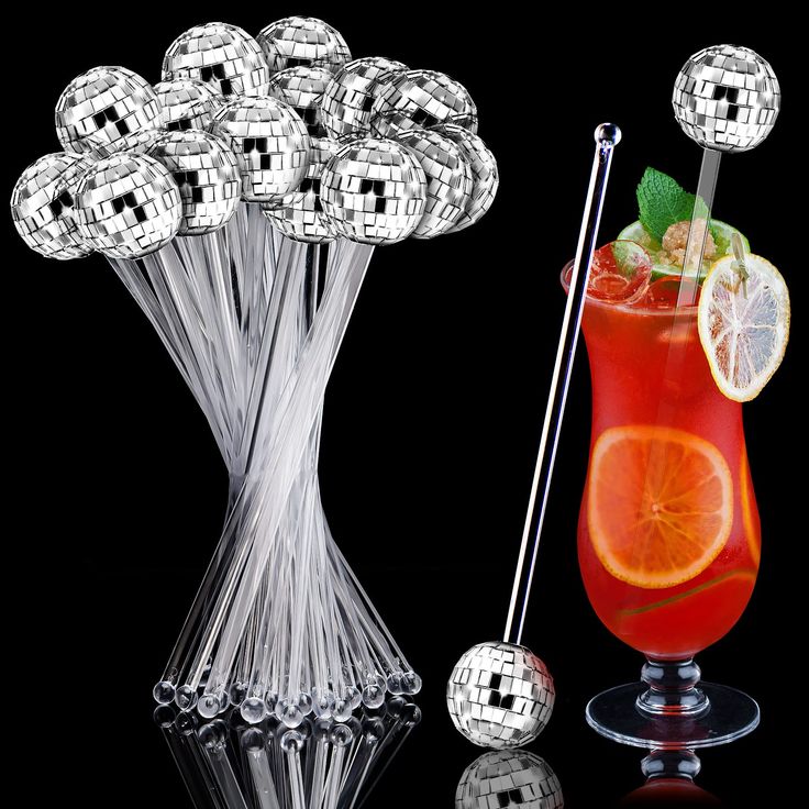 a glass vase filled with oranges next to a cocktail