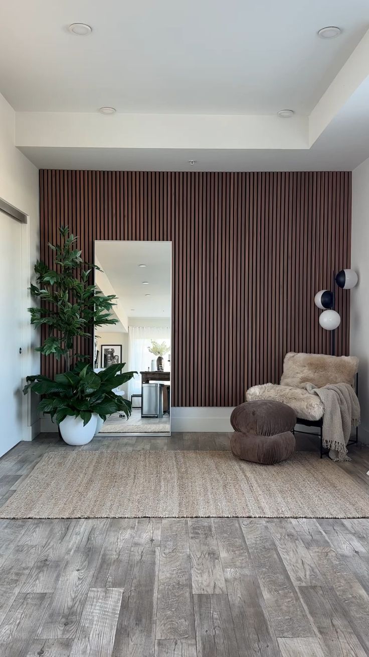 a living room filled with furniture and a large mirror on the wall next to a potted plant