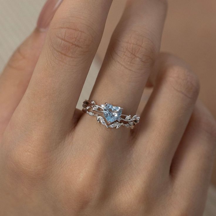 a woman's hand with a ring on it and a blue topazte