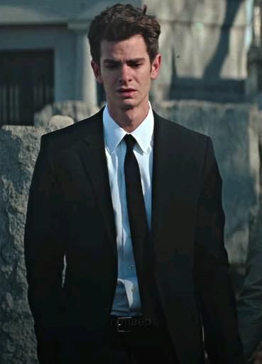 a man in a suit and tie standing outside