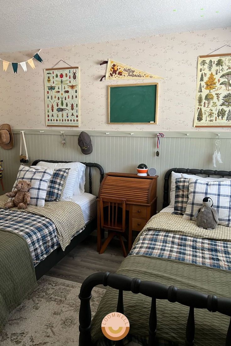 two twin beds in a room with wallpaper and pictures on the walls above them