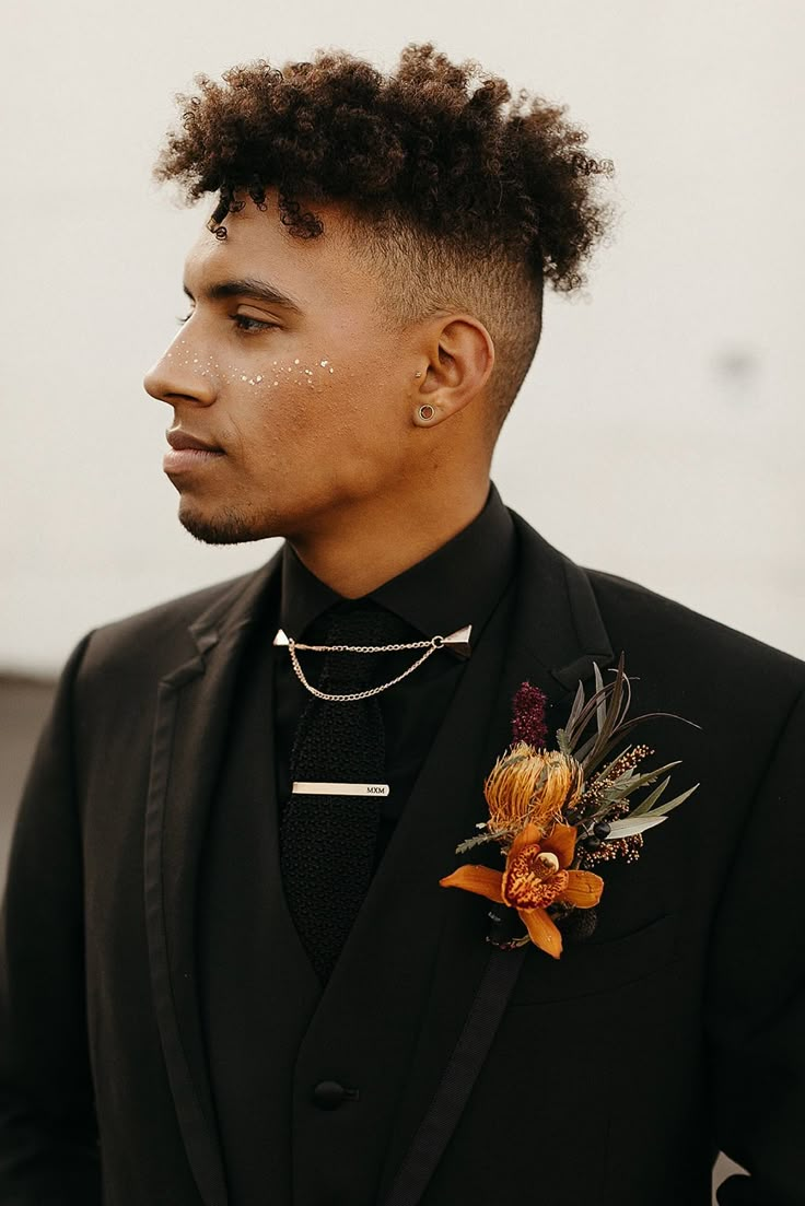 a man wearing a black suit and flower boutonniere