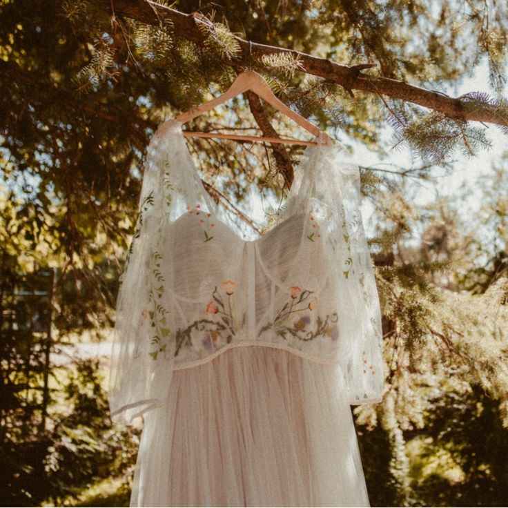 a white dress hanging from a tree branch