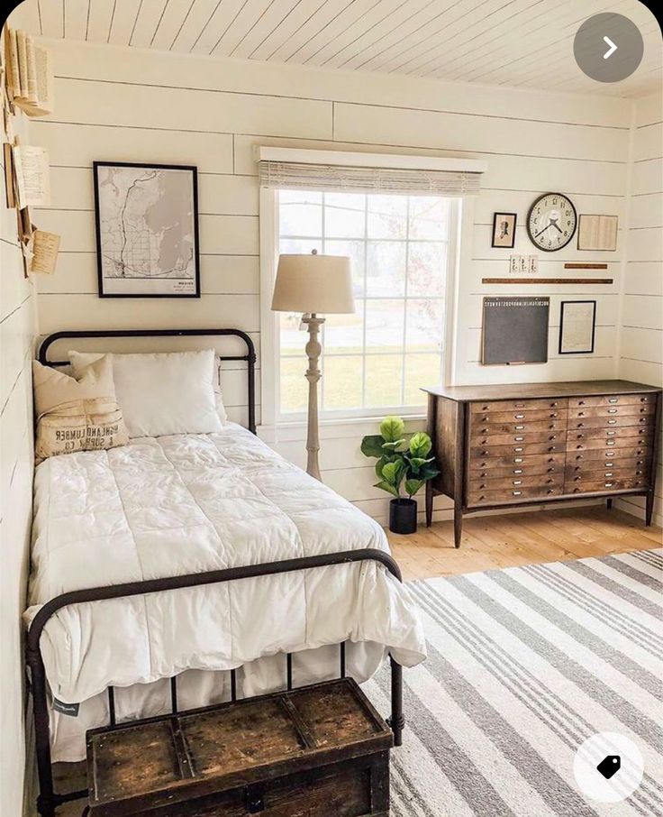 a bedroom with white walls and wood floors