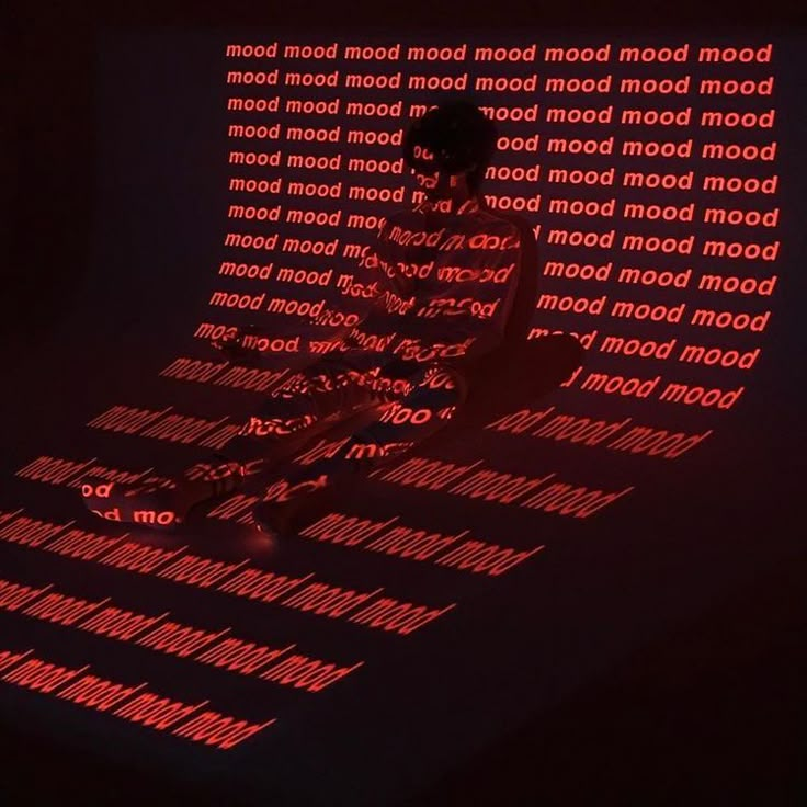 a man standing in front of a wall with words projected on it