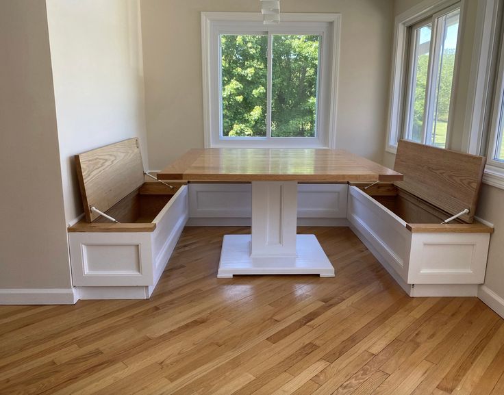 an empty room with wooden flooring and built - in benches on the side