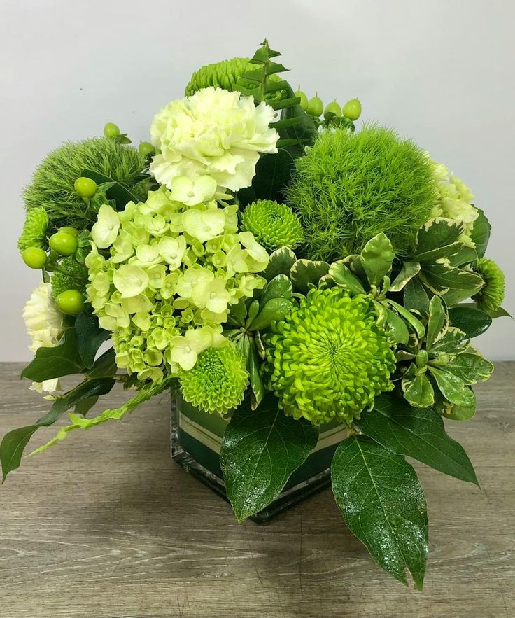 a vase filled with green and white flowers