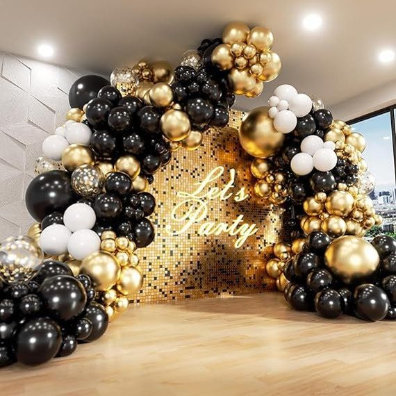 black and gold balloons are arranged in the shape of an arch with white, black, and gold balloons