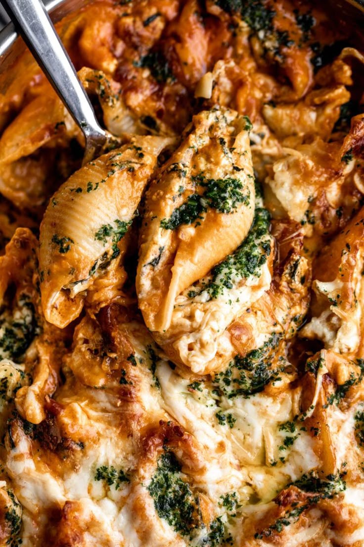 a pan filled with chicken and spinach covered in cheese, sauce and parmesan