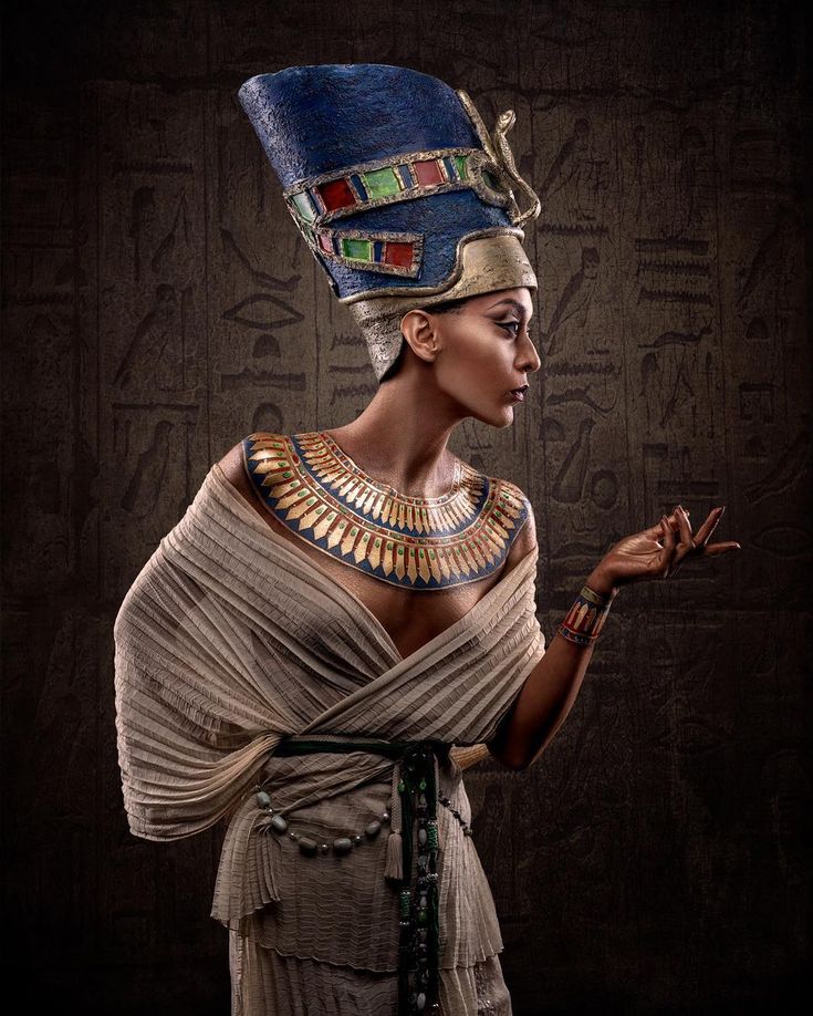 an egyptian woman dressed in ancient clothing and headdress, holding her hand out to the side