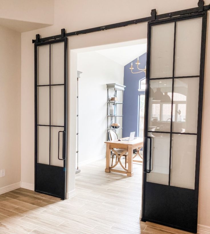 an open door leading to a dining room with wood flooring and white painted walls