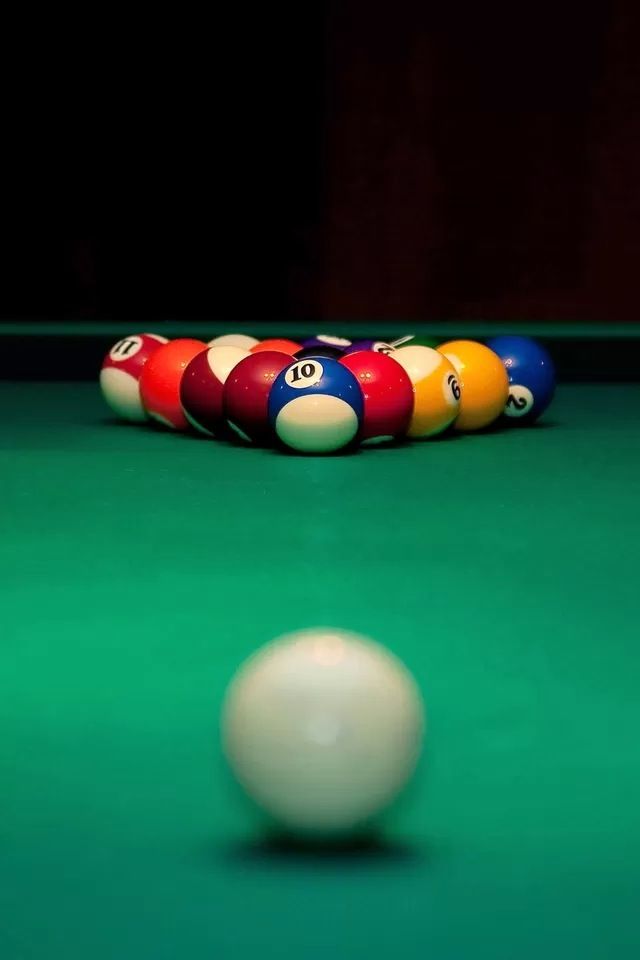 a pool table with several billiards on it and a ball in the foreground