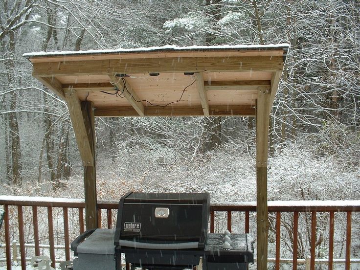 an outdoor grill in the snow on a deck