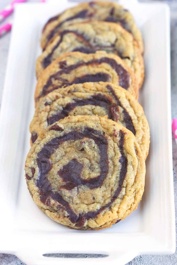 chocolate chip cookies on a white plate with pink sprinkles around the edges