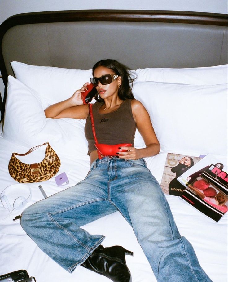 a woman laying in bed talking on the phone