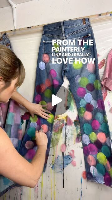 a woman is painting jeans on the wall