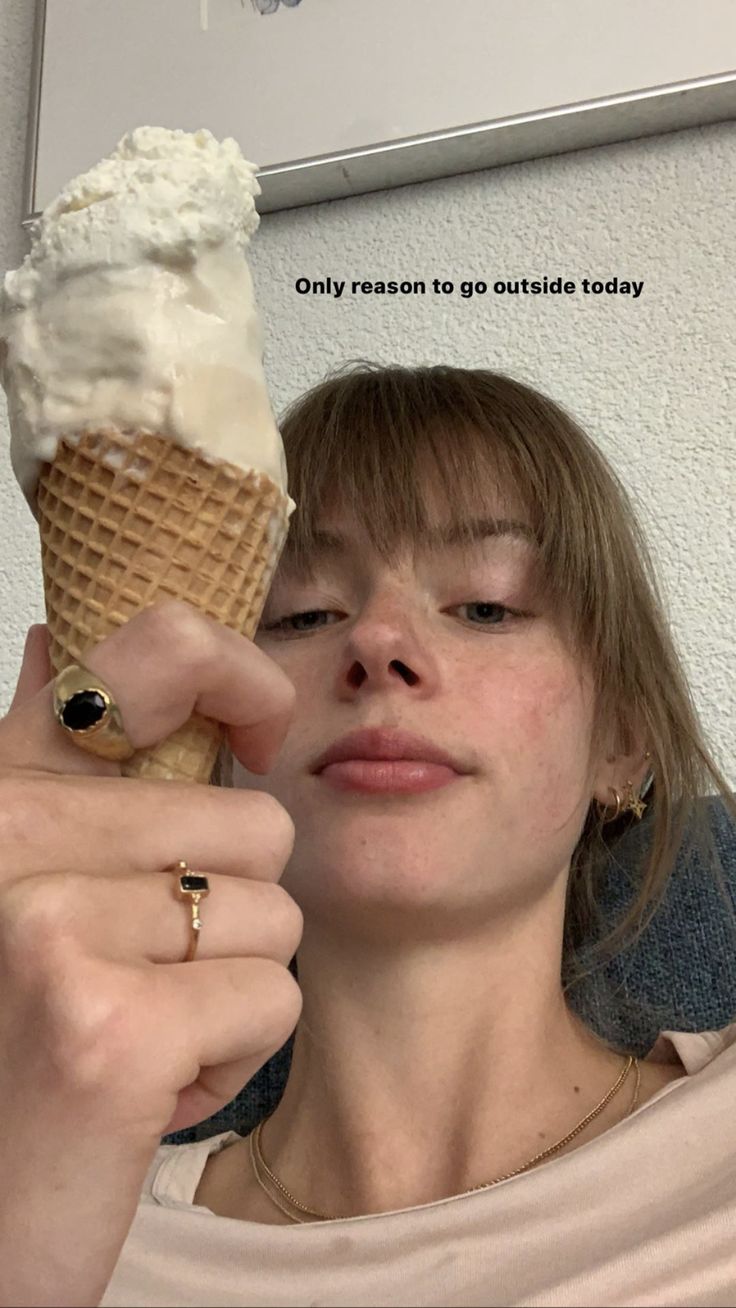 a woman holding an ice cream cone in her hand