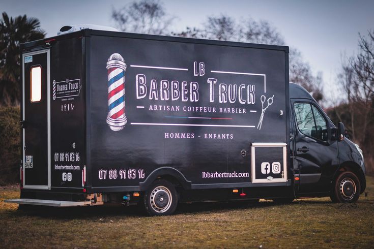 a barber truck is parked in the grass