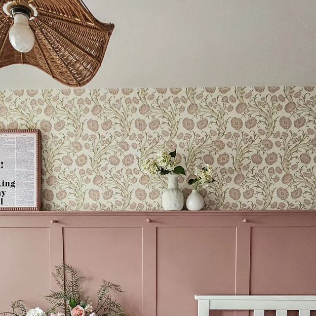 a room with pink walls and floral wallpaper