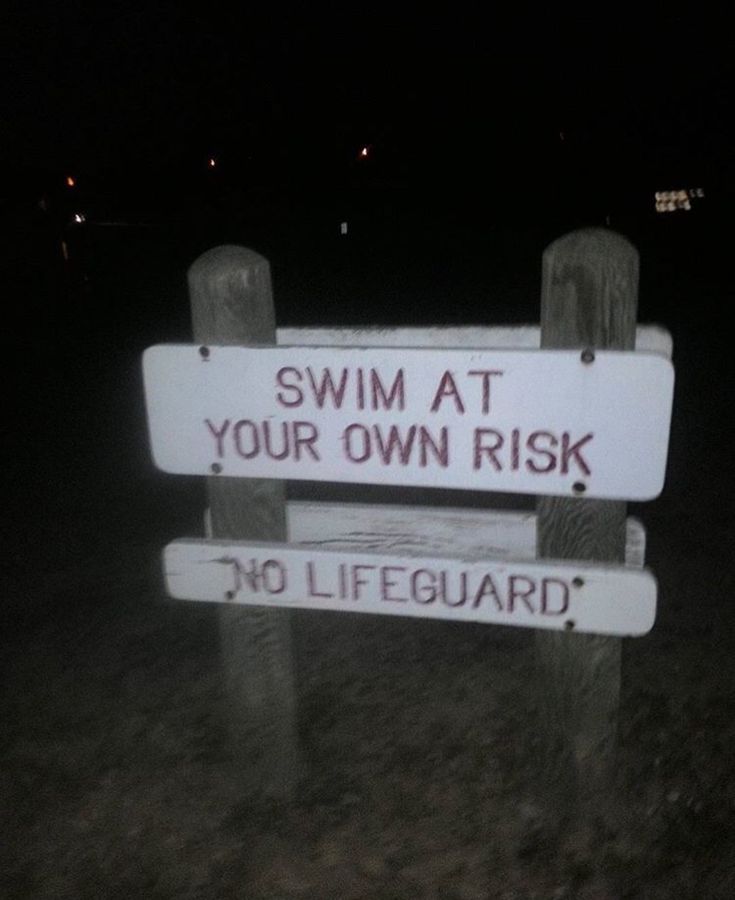 a sign that says swim at your own risk and no lifeguard