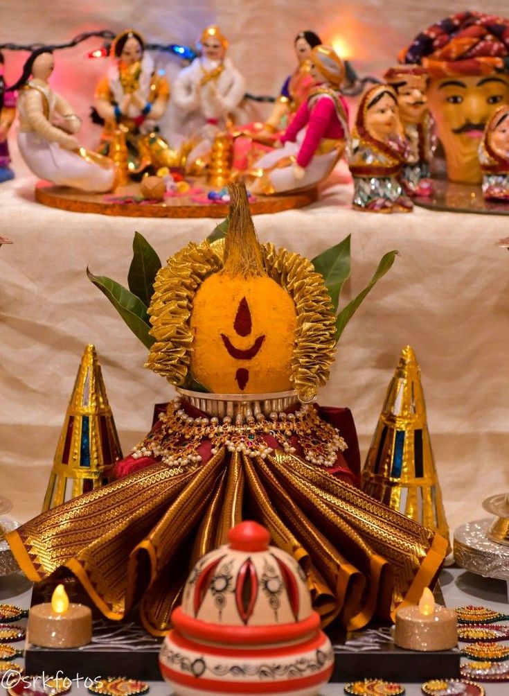 there are many figurines on the table with candles in front of them and one is wearing a crown