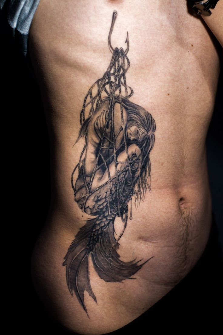 a man with a tattoo on his stomach has a fish in it's belly