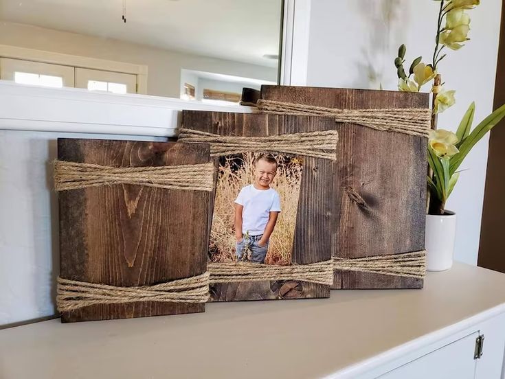 two wooden frames with twine on them are sitting on a counter in front of a mirror