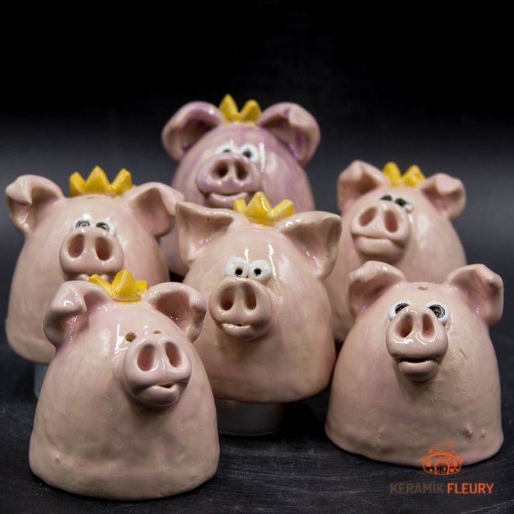 five ceramic pig figurines with yellow crowns on their heads, all facing different directions