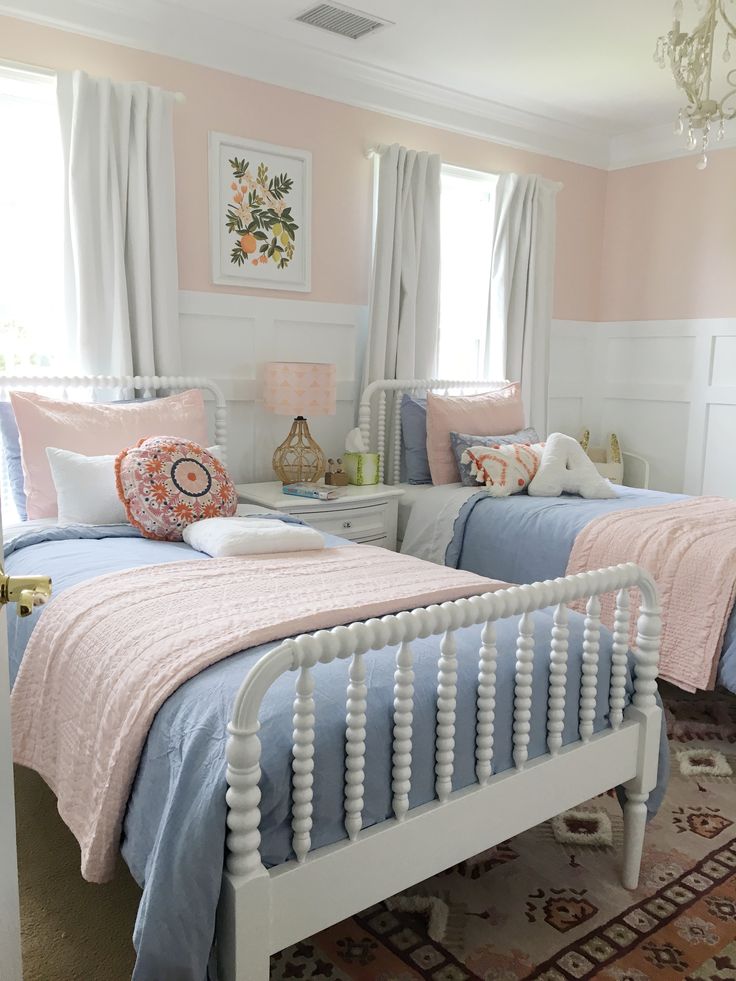 two twin beds in a pink and white bedroom