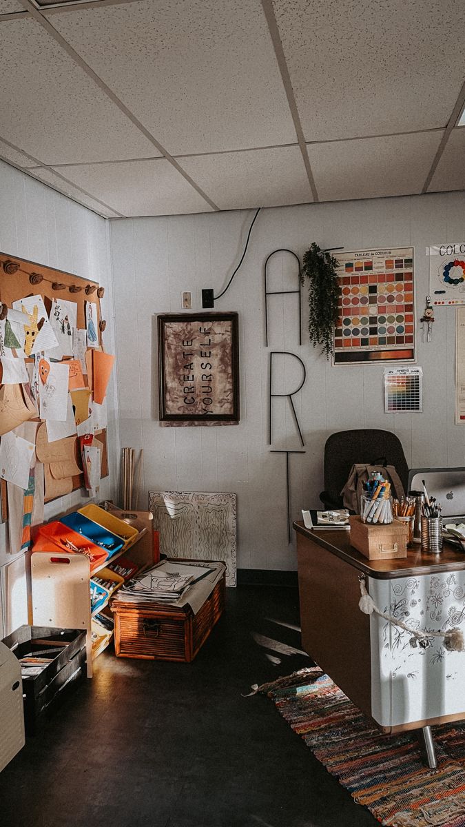 an office with lots of clutter and papers on the desk, along with other items