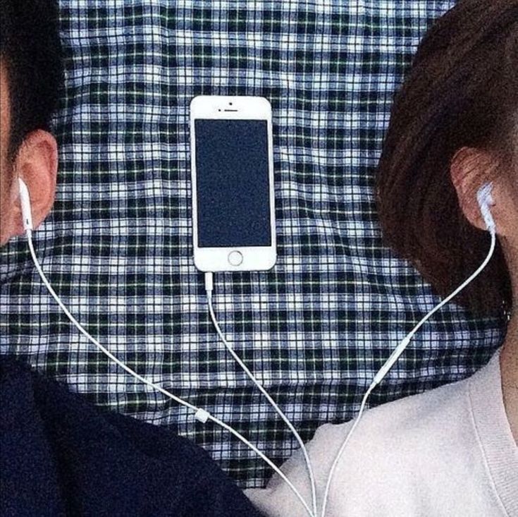 two people with ear buds and cell phones