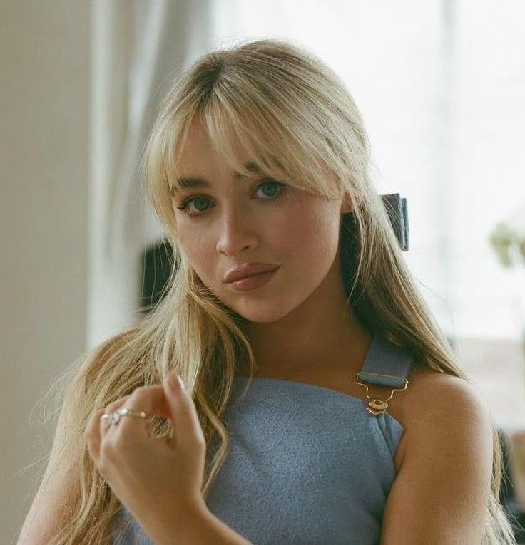 a blonde woman in a blue dress is posing for the camera